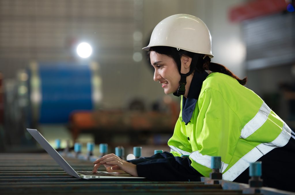 Portrait of a heavy equipment female engineer from a huge industry who came to inspect the metal sheet factory's machinery.